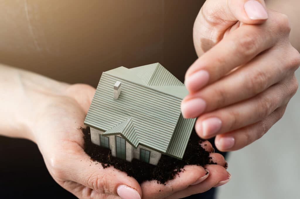 hands holding paper house model